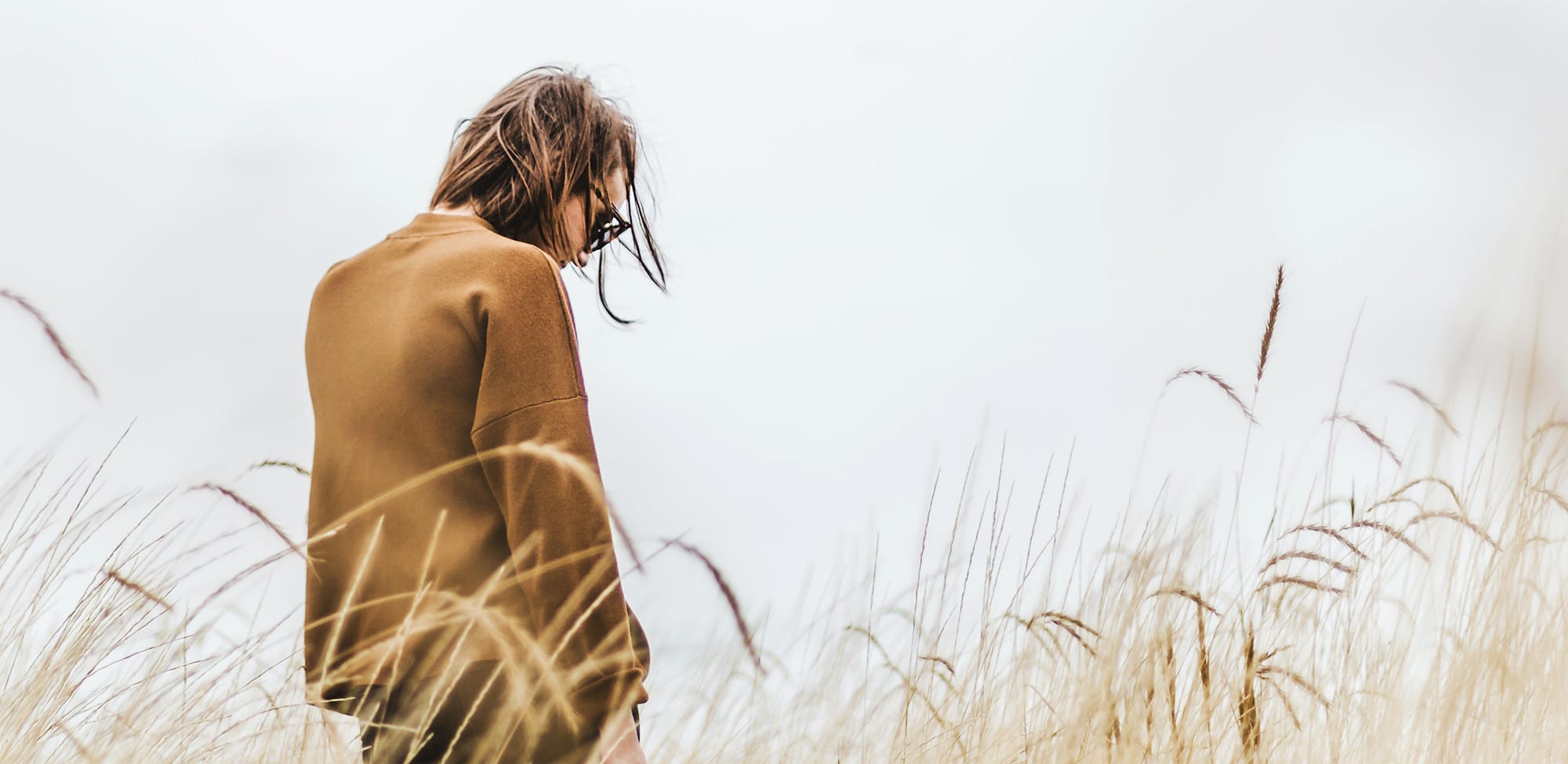 A man looking down in a field.
